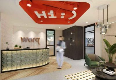 Modern reception area with a curved desk, bright orange ceiling feature, and branded wall signage.