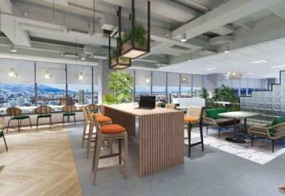 Open-plan office space featuring a wooden communal table, orange bar stools, and city views.