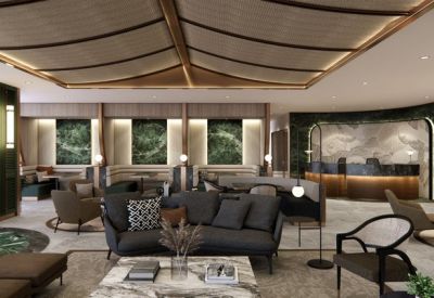 Lobby area with a dark grey sofa, marble coffee table, and soft cove lighting.