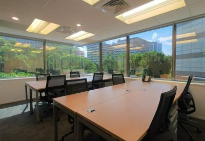 Bright corner office with multiple desks and large windows