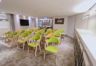 Training room with rows of lime green chairs and a white counter