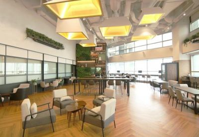 Bright coworking area featuring armchairs, coffee tables, and large windows.
