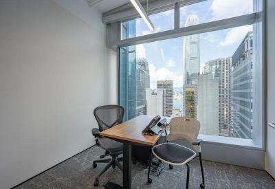Private window office with a wooden desk and impressive views of the city skyline.