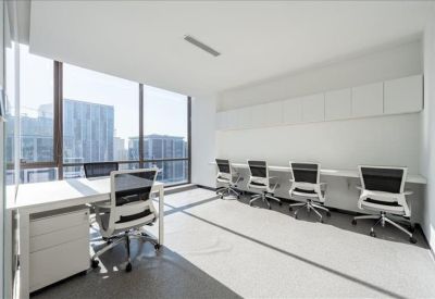 Private office suite with a large window and multiple white workstations.