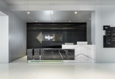 Modern reception desk featuring marble finishes and an illuminated logo.