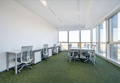 Bright co-working area with individual desks and green artificial grass flooring.