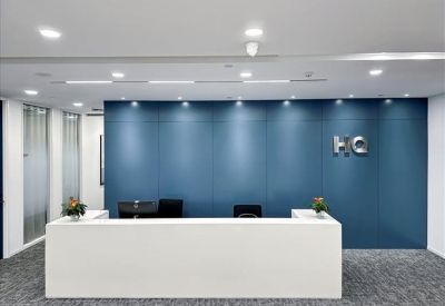 Minimalist white reception desk set against a deep blue panelled feature wall.