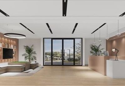 Warmly lit lounge area with grey sectional seating and a large sliding glass door.