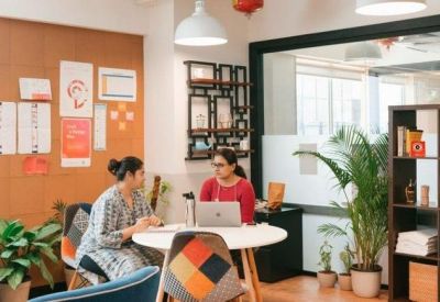 Two-person meeting area with colorful chairs and wall decor.