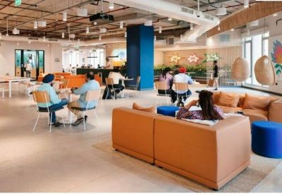 Relaxed lounge area with brown couches and hanging chairs.