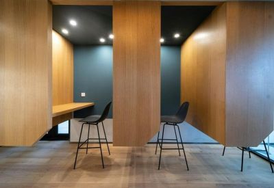 Private wood-paneled focus pods with high stools and integrated desks.