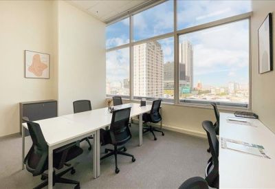 Bright multi-desk office suite with a large window and city views.