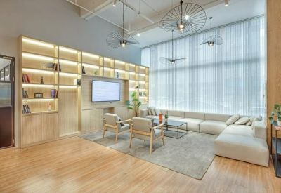 Communal lounge with a floor-to-ceiling bookshelf and large windows with sheer curtains.