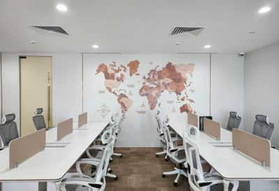 Bright open-plan office with white desks and a world map feature wall.
