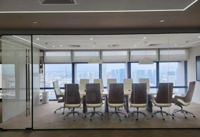 Large boardroom featuring a long table and high-back chairs behind a glass partition.