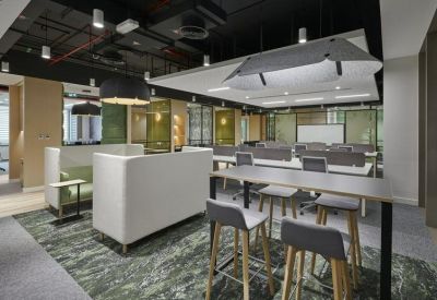 Spacious open-plan workspace with high-top collaboration tables and acoustic ceiling baffles.