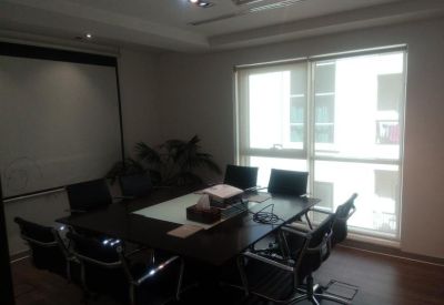 Professional meeting room featuring a dark wood conference table and a large projector screen.