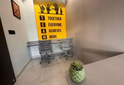 Office nook featuring a bright yellow motivational wall graphic.
