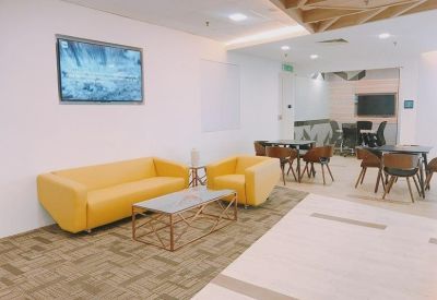 Modern lounge area with bright yellow sofas and a decorative wooden ceiling.