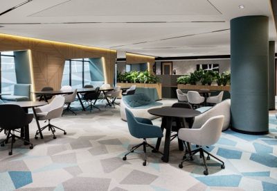 Spacious lounge area with colorful armchairs and geometric patterned blue carpet.