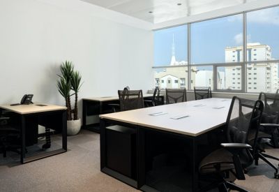 Bright private office suite with large windows and multiple workstations.