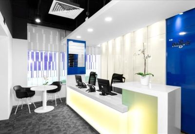 Bright reception area with a white marble-look desk and blue glass feature wall.