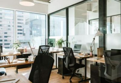 Bright open-plan office with ergonomic chairs and large windows overlooking the city.