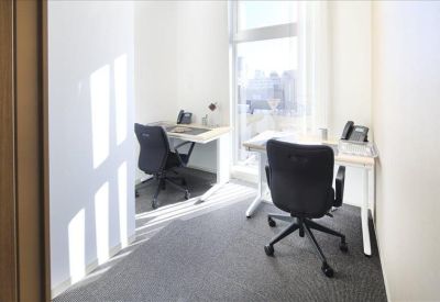 Private two-person office suite with bright natural light from a window.