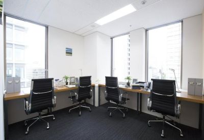 Four-person private office suite with ergonomic chairs, wood-topped desks, and large bright windows.