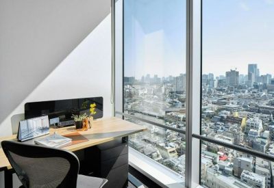 Individual workstation desk beside a floor-to-ceiling window with city views.
