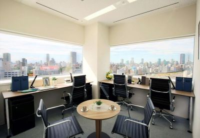 Private office suite with two workstations and wide windows showing a cityscape view.