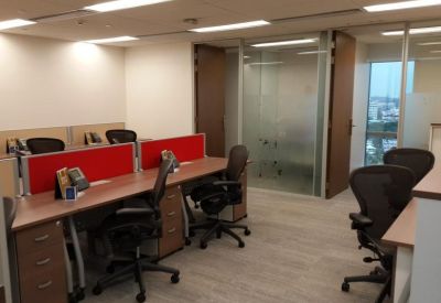 Well-lit workstation area featuring desks with red privacy dividers and matching brown cabinetry.