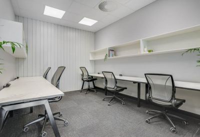 Private office suite with a long desk and white shelving.