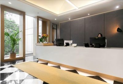Bright, minimalist reception area featuring a sleek white desk and indoor plants.