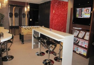 Breakout area with foosball table, white high-top table, and vibrant red feature wall.