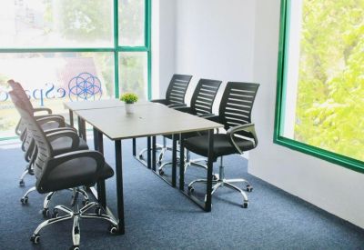 Meeting room with long table, black chairs, and large windows.