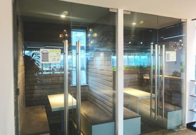 Private glass-enclosed phone booths or focus rooms with bench seating.