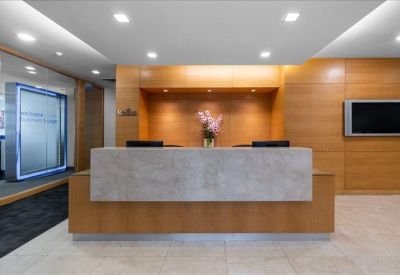 Professional reception desk with a marble-style facade and warm wood wall panels.