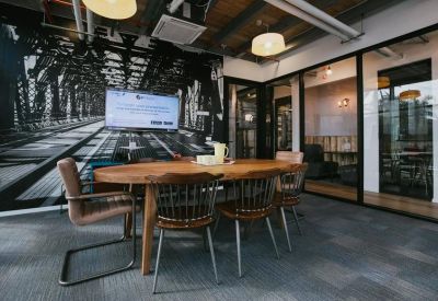 Meeting room featuring a large wooden table and a bridge mural.