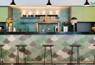 Cafe-style communal bar with green fish-scale tiling and stools.