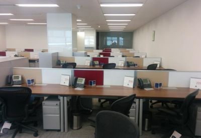 Open-plan workspace with multiple desks and desk dividers.