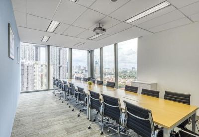 Long wooden conference table in a bright meeting room with expansive city views through floor-to-ceiling windows.