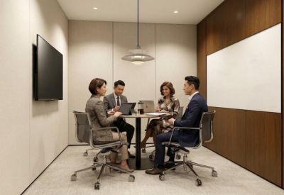 Professional meeting room with a round table, four chairs, and a wall-mounted screen.