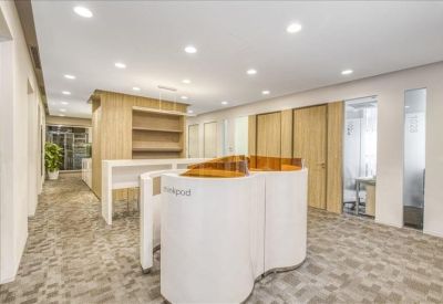 Spacious reception lobby featuring a unique curved white front desk and wood accents.