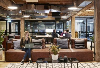 Lounge area with leather seating and people working on laptops.