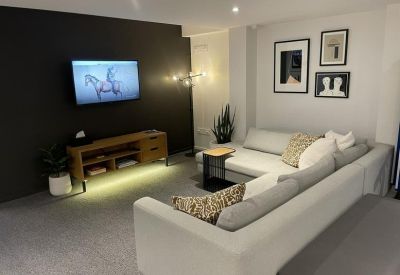 Comfortable lounge area with a large sectional sofa, wooden media console, and wall art.