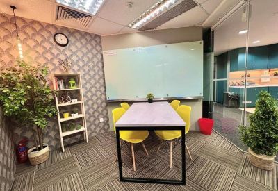 Four-person meeting room with yellow chairs, a whiteboard, and patterned wallpaper.
