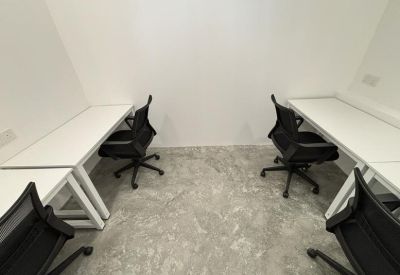 Private office suite with minimalist white desks and ergonomic black chairs on a polished concrete floor.
