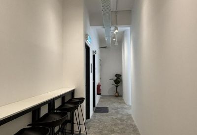 Modern hallway featuring a high-counter breakfast bar with black stools and industrial lighting.