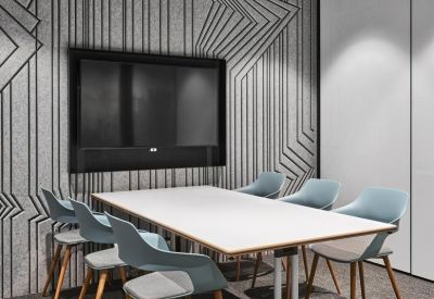 Modern meeting room with a flat-screen TV and stylish blue bucket chairs.
